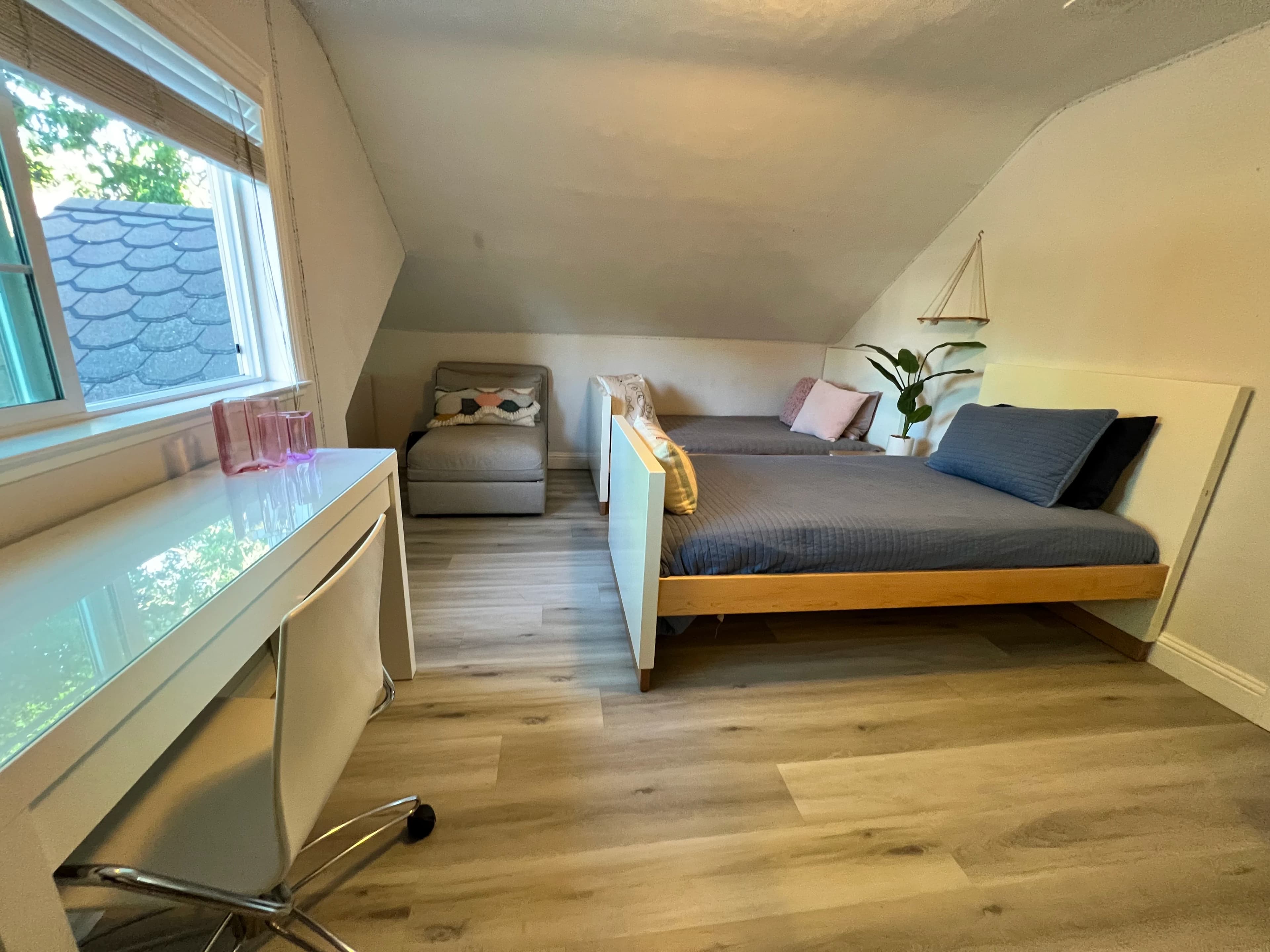 Bright guest room with beds and a workspace